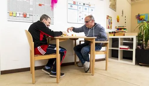 Zwei Männer sitzen an einem Tisch und spielen etwas