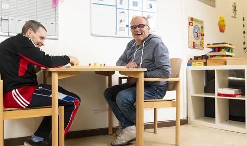 Zwei Männer sitzen an einem Tisch und spielen etwas