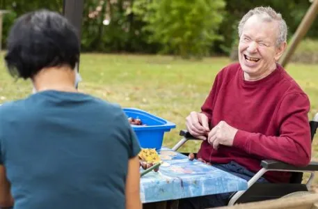 Ein Mann sitzt am Tisch im Garten
