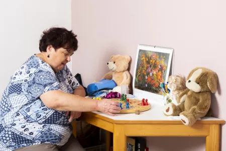 Frau sitzt an einem Tisch mit Plüschtieren