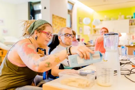 Die Lehrkraft führt mit einem Schüler der Berufsschulstufe ein Experiment durch