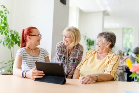 Drei Frauen am einem Laptop im Quartiersmanagement