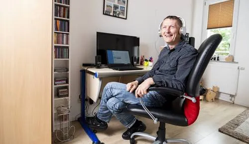 Ein Mann mit Kopfhörer sitzt an einem Schreibtisch