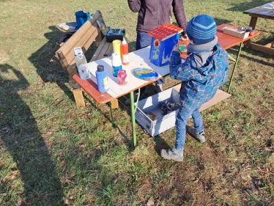 Ein Kind bemalt einen Nistkasten