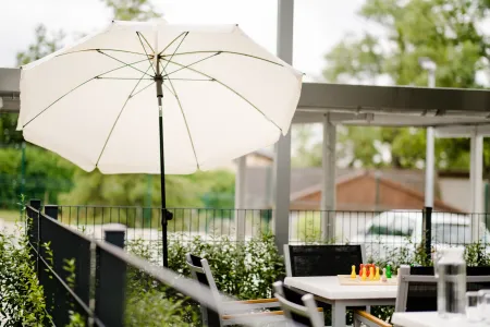 Außenanlage mit Sonnenschirm, Tisch und Stühlen