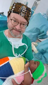 Dr. Klaus Schwendner mit schlafendem Kind