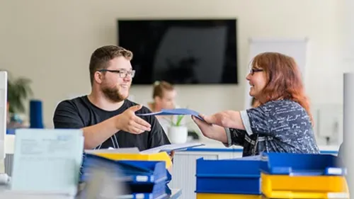 Ausbilderin erklärt Azubi etwas am Computer