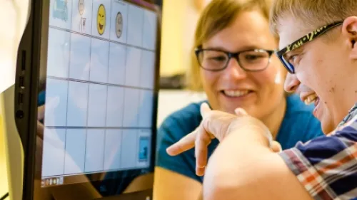 Ein Kind sitzt vor einem Bildschirm im Rollstuhl