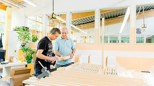 Zwei Menschen arbeiten mit Holz