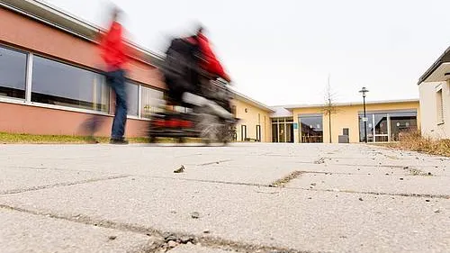 Elektrorollstuhl fährt zum Eingang der Werkstatt