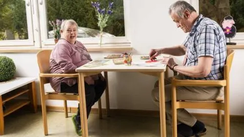Zwei Menschen sitzen an einem Tisch