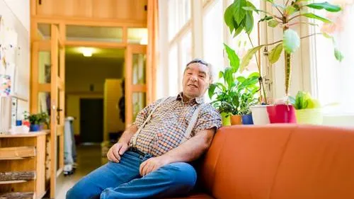 Ein Bewohner sitzt auf einem Sofa