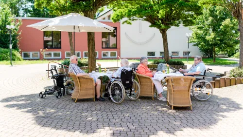 Menschen mit Stühlen und Rollstühlen