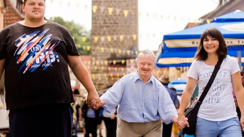 Drei Menschen laufen an der Hand durch Hassfurt