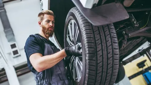 Mann wechselt Reifen
