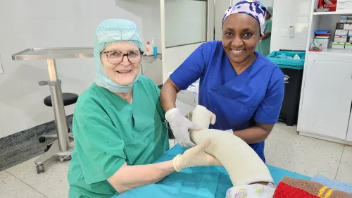 Schwester Grace Ayoo Küfner und Dr. Annemarie Schraml gipsen ein Bein.