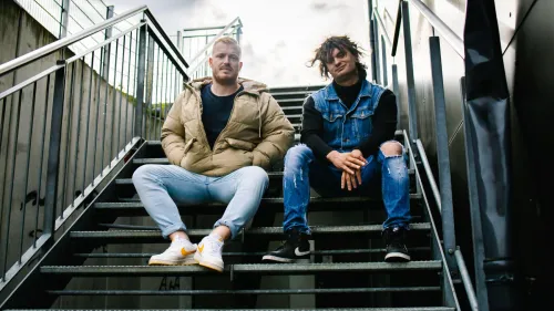 Zwei junge Erwachsene sitzen auf einer Treppe. 