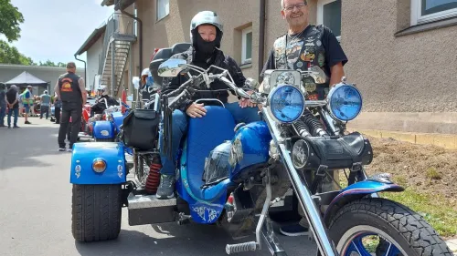 Menschen mit und ohne  Behinderung warten auf die erste Motorradausfahrt