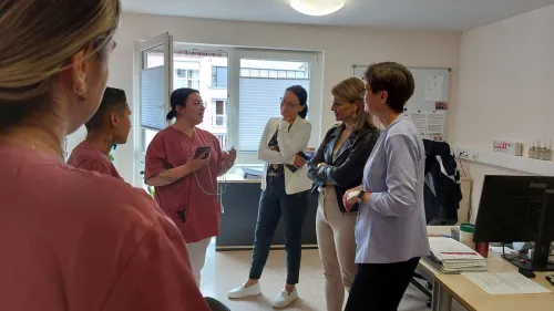 Drei Pflegefachkräfte zeigen Diakonin Heidrun Martini (Mitte), der Abgeordneten Katrin Staffler (zweite von rechts) und der Vorständin des diakonischen Werks Sandra Schuhmann (rechts) die neue Spracherkennungssoftware „dexter“.