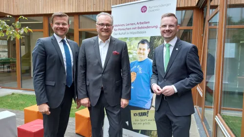 Nürnbergs Oberbürgermeister Marcus König, der Rummelsberger Vorstand Karl Schulz und Bezirkstagspräsident Peter Daniel Forster feiern das 30. Jubiläum der Muschelkinderschule für Kinder mit Autismus.