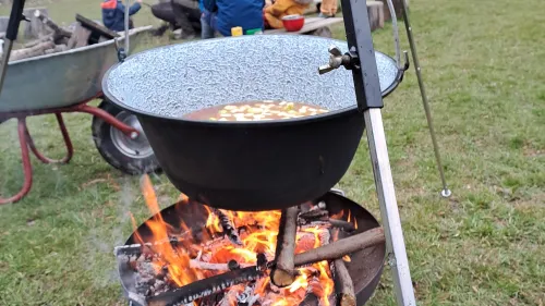 Gemüsesuppe kocht in einem hängenden Topf über dem Lagerfeuer