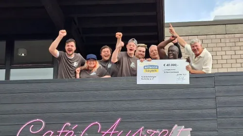 Andreas Ammon, Leiter des Auhofs (r.), Klient*innen und Mitarbeitende freuen sich über die Wiedereröffnung des Cafés. Der Umbau wurde unter anderem durch eine Förderung der Stiftung ANTENNE BAYERN sowie die Aktion Mensch möglich gemacht. 