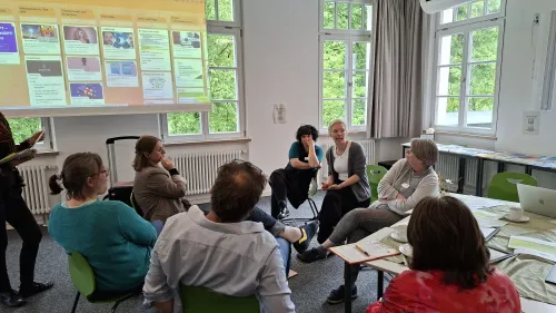 Das Bild zeigt die Medienpädagogin Ramona Engl im Gespräch mit Teilnehmer:innen des Fachtags