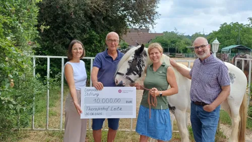 Dagmar Hauck, Fundraising Rummelsberger Diakonie, Ekkehard Lorenz, Vorstand Dommer-Stiftung, Sandra Uhl, Leiterin Therapiehof Leila und Diakon Thomas Jacoby, Leiter Wichernhaus, bei der Übergabe des symbolischen Schecks